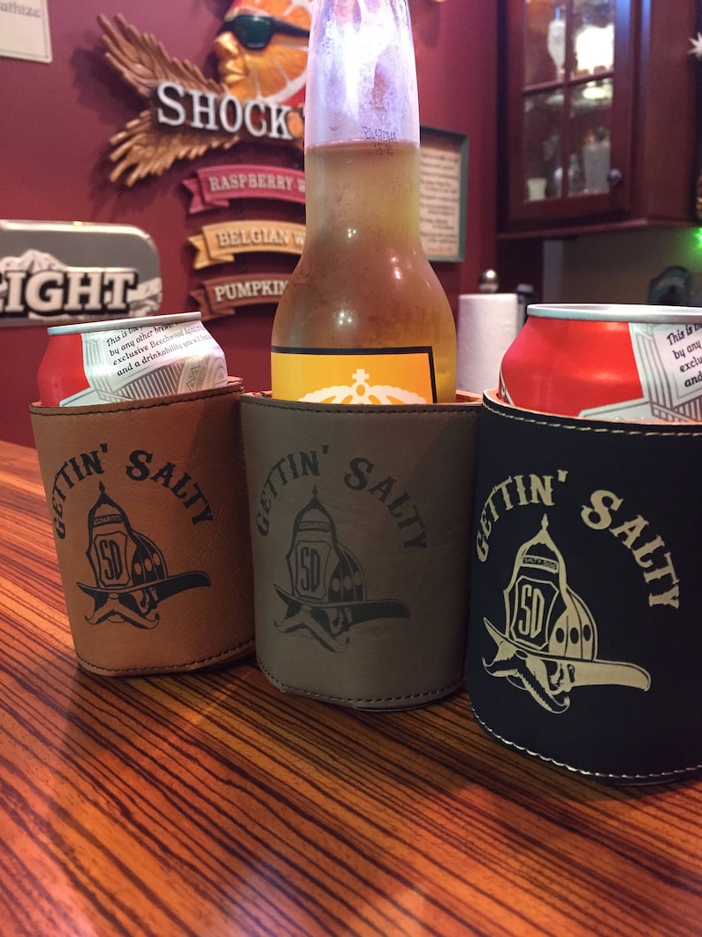 May include: Three brown leather can coolers with the text "Gettin' Salty" and a firefighter helmet logo. The coolers are holding a beer bottle and two cans.
