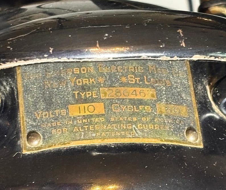 May include: Close-up of a vintage metal plate with text. The plate is attached to a black surface. Text includes "Jefferson Electric Mfg. New York, St. Louis, Type 28646, Volts 110, Cycles 60, Made in United States of America for Alternating Current, Patented."