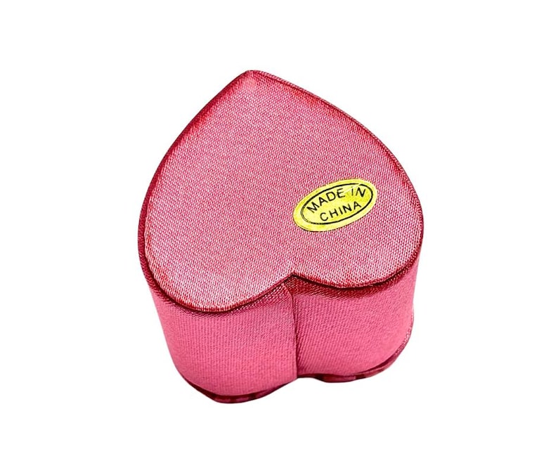 May include: A pink heart-shaped velvet jewelry box with a gold label that reads "MADE IN CHINA".