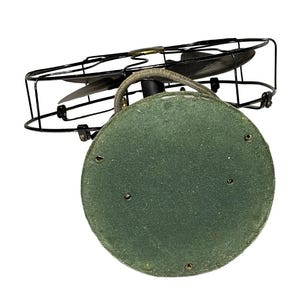May include: An antique electric fan with a black metal cage and blades. The base is a circular shape covered in green felt. The fan's design is vintage, with a focus on functionality and a classic aesthetic.