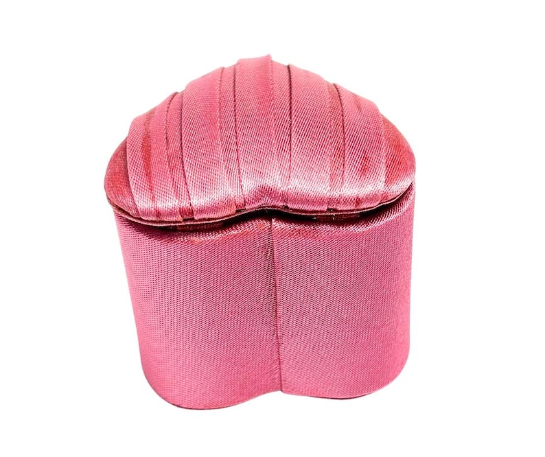 May include: A pink heart-shaped jewelry box with a satin finish.