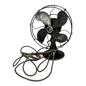 May include: An antique Emerson electric fan with a black metal frame and blades. The fan has a circular cage and a base, with a power cord extending from the bottom. The blades are black and silver.