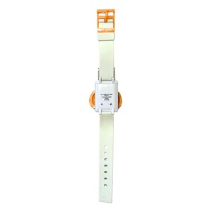 May include: A vintage digital watch with a white strap and an orange buckle. The watch face is orange and square, with a white casing. The strap has multiple holes for adjustment. The watch is a retro accessory.