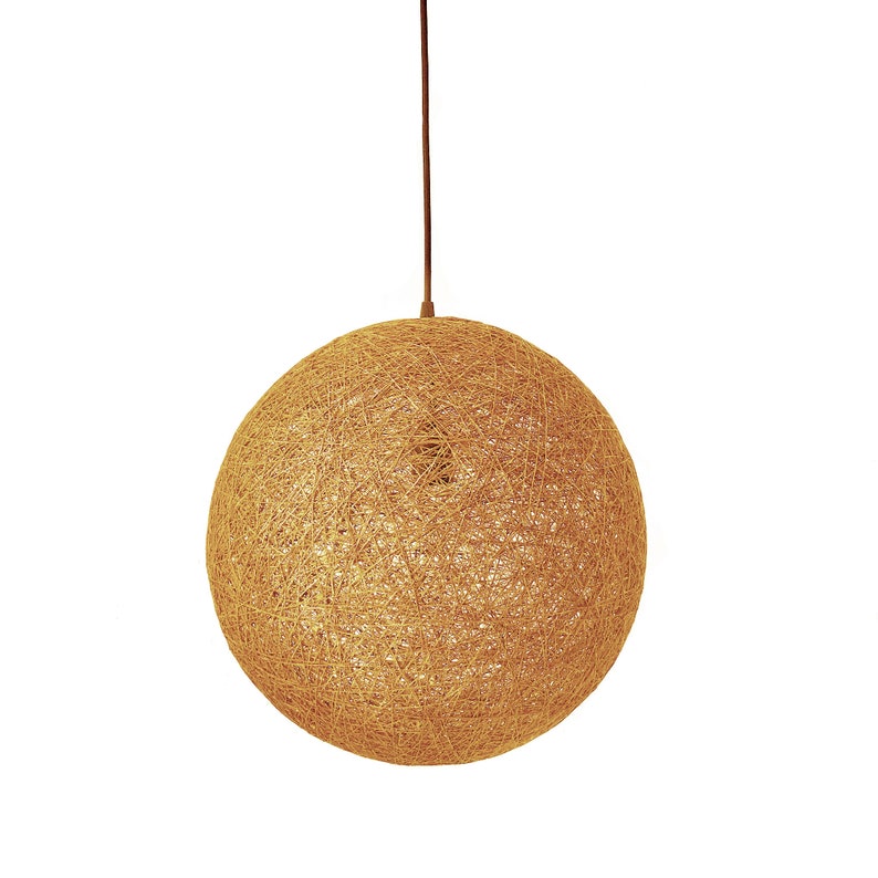 Peut inclure: Un luminaire suspendu rond en fibres naturelles tress&eacute;es. Le luminaire est suspendu &agrave; un cordon brun.