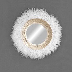 May include: A round mirror with a white feather trim and a natural fibre rope frame.