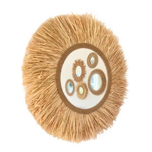 May include: A round straw mirror with a woven rope frame and multiple smaller mirrors inside. The mirror has a natural, rustic look.