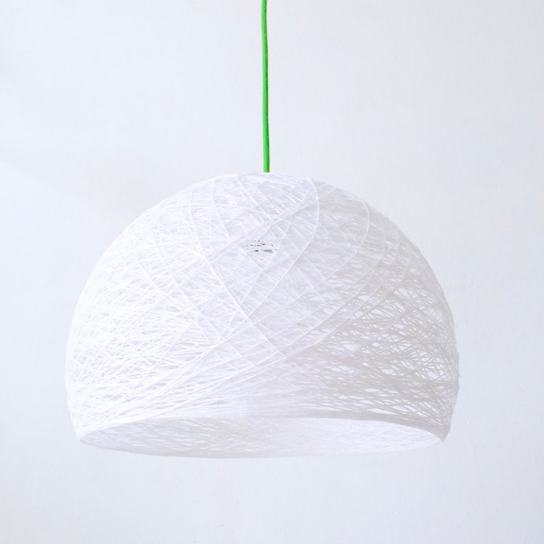 May include: A white, string-like pendant light fixture with a green cord hanging from the ceiling.
