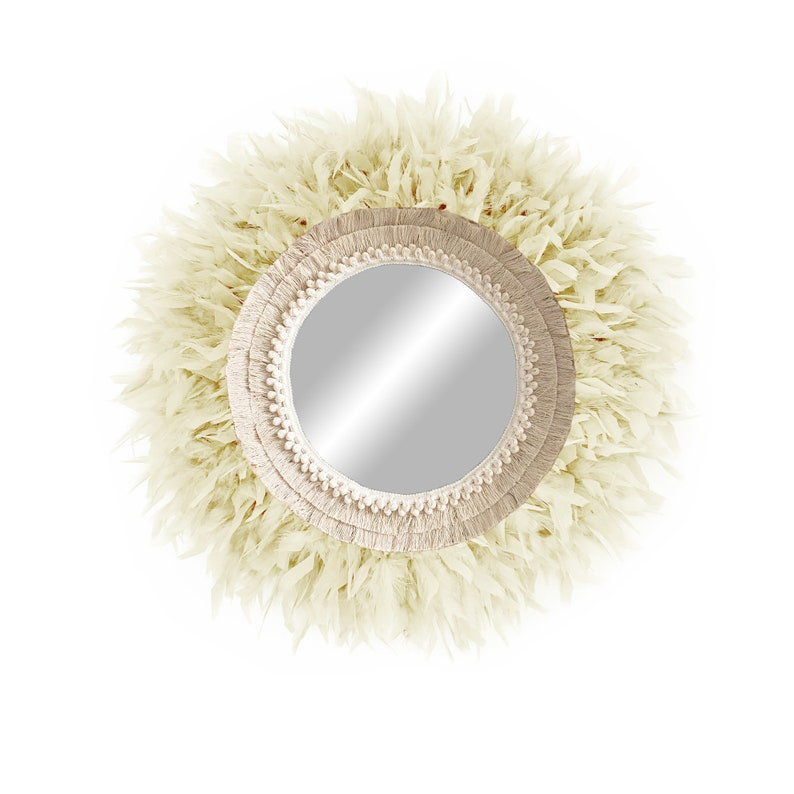 May include: A round mirror with a cream-coloured, fringed frame. The frame is made of woven rope and has a natural, bohemian style.