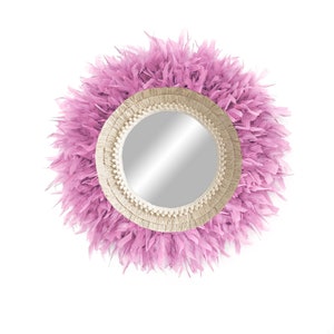 May include: A round mirror with a pink feather trim and a natural fibre rope frame.