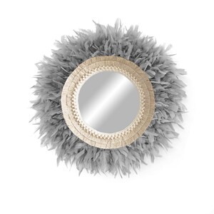 May include: A round mirror with a grey feather trim and a natural fibre frame. The mirror has a simple, modern design.