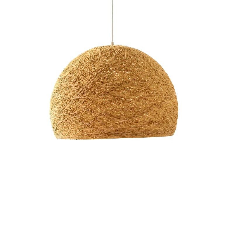 May include: A large, round, woven pendant light fixture made of natural fibers. The light is a warm, light brown color and has a natural, organic look.