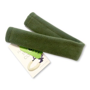 May include: A green fleece strap for a dog lead. The strap is approximately 2.5 cm wide and 45 cm long. The strap is made of soft fleece and is designed to be comfortable for dogs to wear. The strap is attached to a lead with a metal clip. The strap is labelled "Have a Safe Walk!"
