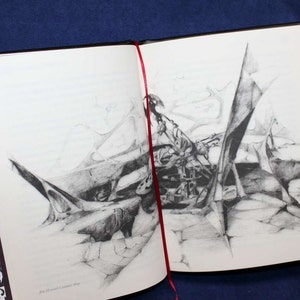 May include: A black and white pencil drawing of a complex, abstract design. The drawing is on a white page in a black bound book.