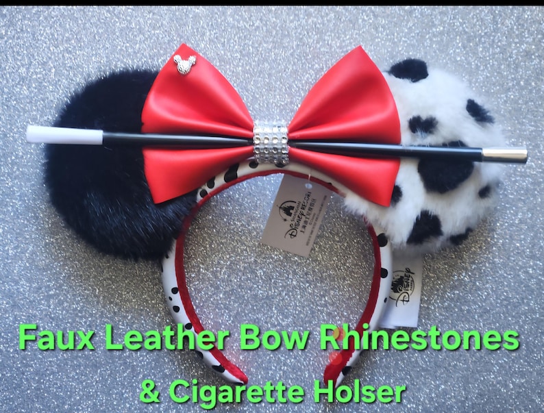 May include: A headband featuring one solid black faux fur ear and one white faux fur ear with black spots. A large red faux leather bow sits in the center, accented by a silver Mickey icon and a rhinestone band. A black and white prop wand is attached.