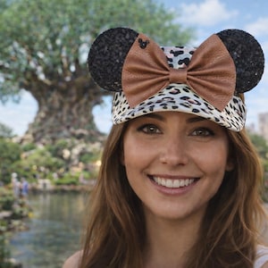 May include: A set of three ceramic mugs with a speckled, cream-colored glaze. Each mug features a different hand-painted floral design in shades of blue, green, and yellow. The mugs have a simple, rounded shape and a comfortable handle.