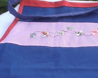 May include: A blue and pink striped apron with a red trim and embroidered bees and flowers.
