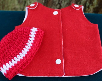 May include: A red felt vest with white trim and white buttons, paired with a red and white crocheted hat.