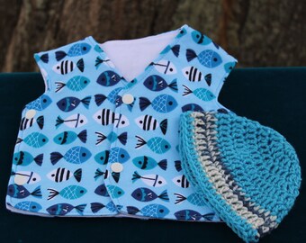 May include: A blue and white baby vest with a fish pattern and a matching blue and white crocheted hat.