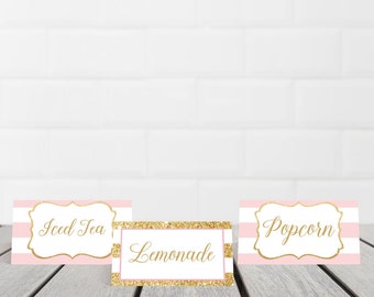 May include: Three pink and white striped table cards with gold lettering. The cards read "Iced Tea", "Lemonade", and "Popcorn".