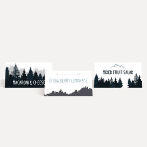 May include: Three white cards with black and white mountain and forest designs. The cards read "MACARONI & CHEESE", "STRAWBERRY LEMONADE", and "MIXED FRUIT SALAD" in a handwritten font. The cards are arranged on a white background.