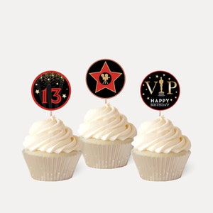 May include: Three cupcakes with red, black, and gold themed cupcake toppers. The toppers feature a star with a film camera, a star with the number 13, and a star with the text "VIP" and a golden statue.