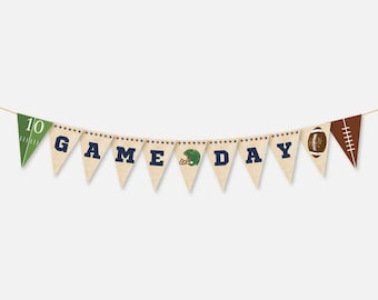 Puede incluir: Una pancarta marrón y blanca con las palabras "GAME DAY" en letras azules. La pancarta tiene un balón de fútbol, un casco de fútbol y un campo de fútbol.
