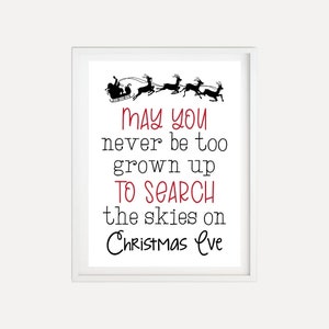 Op de afbeelding: Een witte ingelijste print met een zwart silhouet van Sinterklaas en rendieren die door de lucht vliegen. De tekst luidt "May you never be too grown up to search the skies on Christmas Eve".