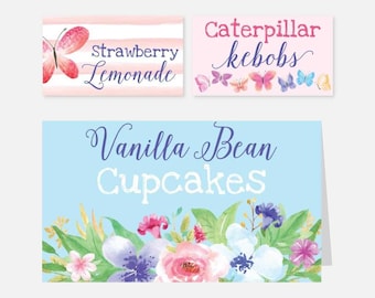 Peut inclure: Trois étiquettes alimentaires imprimables sur le thème floral. L'étiquette en haut à gauche est rose avec des rayures blanches et dit "Strawberry Lemonade". L'étiquette en haut à droite est rose et dit "Caterpillar Kebobs". L'étiquette du bas est bleu clair avec un motif floral et dit "Vanilla Bean Cupcakes".