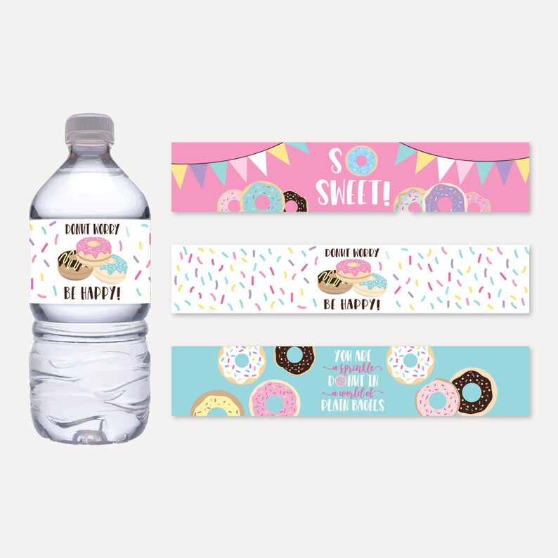 May include: Water bottle labels with a donut theme. The labels feature pink, blue, and white colors with sprinkles and donuts. The text on the labels reads "Don't worry, be happy!" and "You are a sprinkle donut in a world of plain bagels".
