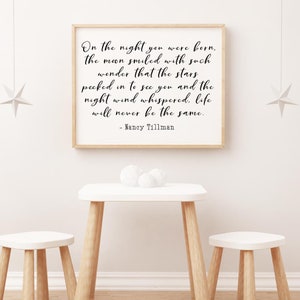 Op de afbeelding: Een ingelijst afdruk met een witte achtergrond en zwarte tekst. De tekst luidt: "On the night you were born, the moon smiled with such wonder that the stars peeked in to see you and the night wind whispered, life will never be the same. - Nancy Tillman"