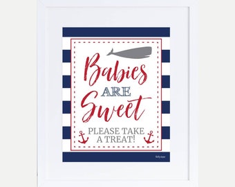 Könnte beinhalten: Ein weiß gerahmtes Schild mit blau-weiß gestreiftem Hintergrund. Das Schild sagt "Babies are Sweet" in roter Kursivschrift mit einer grauen Wal-Silhouette über dem Text. Das Schild hat auch zwei Anker und den Text "Please take a treat!" in rot.