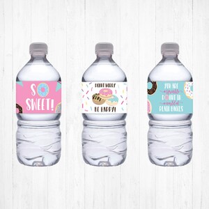 May include: Three water bottles with colorful labels featuring donut illustrations and puns. The labels read "So Sweet!", "Donut Worry Be Happy!" and "You are a sprinkle donut in a world of plain bagels".