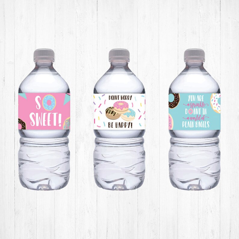 May include: Three water bottles with colorful labels featuring donut illustrations and puns. The labels read "So Sweet!", "Donut Worry Be Happy!" and "You are a sprinkle donut in a world of plain bagels".