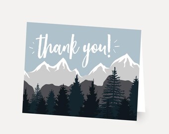 Könnte beinhalten: Eine blaue Dankeskarte mit einer weißen Bergkette und einem Wald aus dunkelgrünen Bäumen im Vordergrund. Der Text "thank you!" ist in weißer Kursivschrift geschrieben.