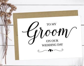 以下が含まれることがあります： 白いカードに黒い文字で「To my groom on our wedding day」と書かれています。カードには茶色の封筒が付いています。