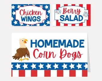 以下が含まれることがあります： 愛国的なテーマの3つの食品サイン。「Chicken Wings」、「Berry Salad」、「Homemade Corn Dogs」と書かれています。サインは赤、白、青の色と星とストライプのパターンを持っています。