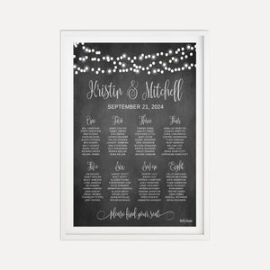 May include: A black chalkboard with white string lights and white text. The text reads "Kristin & Mitchell" and "September 21, 2024". The chalkboard is divided into eight sections, each with a number and a list of names. The text at the bottom reads "Please find your seat."
