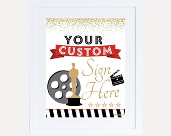 Può includere: Una cornice bianca con un cartello all'interno. Il cartello ha uno sfondo di glitter dorato con una bobina di pellicola in bianco e nero e una statua dorata. Il testo sul cartello dice "Your Custom Sign Here" con cinque stelle dorate sotto il testo.