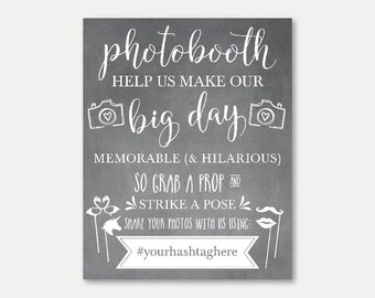 Puede incluir: Un cartel de pizarra con texto blanco que dice "photobooth help us make our big day memorable (& hilarious) so grab a prop and strike a pose share your photos with us using: #yourhashtaghere". El cartel está decorado con dibujos de cámaras, corazones y accesorios de fiesta.