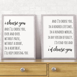 May include: Two framed prints with black text on a white background. The left print reads "i choose you AND I'LL CHOOSE YOU, OVER AND OVER. WITHOUT PAUSE, WITHOUT A DOUBT, IN A HEARTBEAT, I'LL KEEP CHOOSING YOU." The right print reads "AND I'D CHOOSE YOU, IN A HUNDRED LIFETIMES, IN A HUNDRED WORLDS, IN ANY VERSION OF REALITY, I'D FIND YOU AND id choose you".