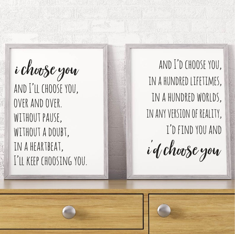 May include: Two framed prints with black text on a white background. The left print reads "i choose you AND I'LL CHOOSE YOU, OVER AND OVER. WITHOUT PAUSE, WITHOUT A DOUBT, IN A HEARTBEAT, I'LL KEEP CHOOSING YOU." The right print reads "AND I'D CHOOSE YOU, IN A HUNDRED LIFETIMES, IN A HUNDRED WORLDS, IN ANY VERSION OF REALITY, I'D FIND YOU AND id choose you".