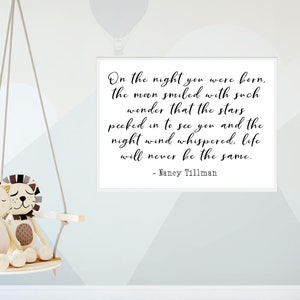 Op de afbeelding: Een wit ingelijst print met een zwart-wit citaat dat luidt: "On the night you were born, the moon smiled with such wonder that the stars peeked in to see you and the night wind whispered, life will never be the same." - Nancy Tillman