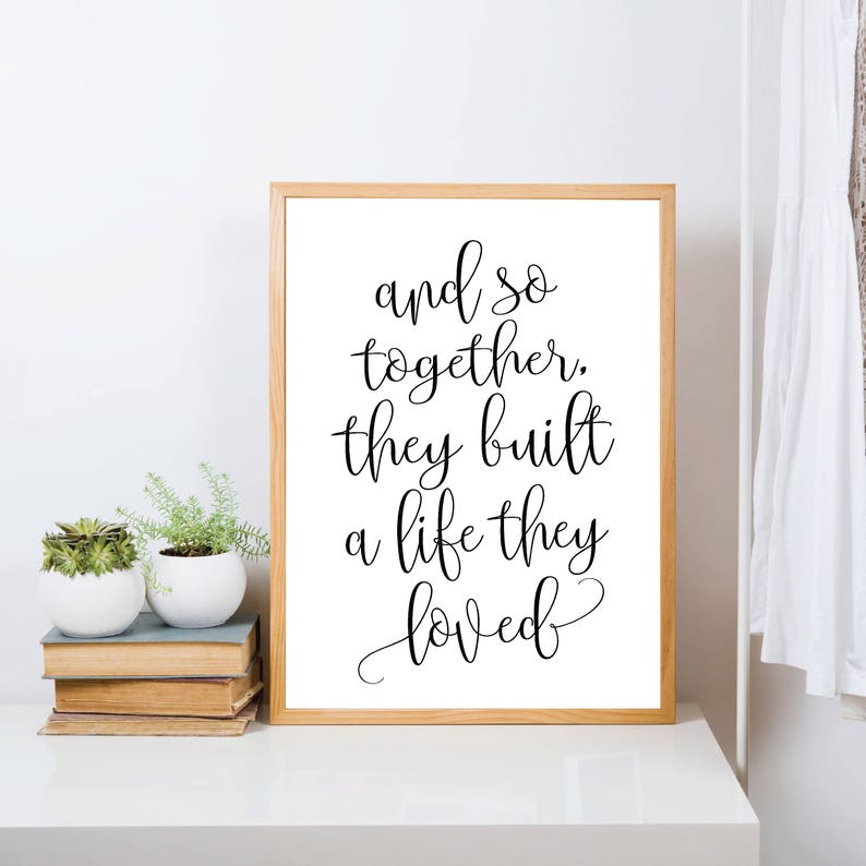 May include: A framed print with a white background and black text that reads "and so together, they built a life they loved".