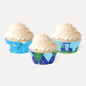 May include: Three cupcake cases with a golf theme. One case is blue with white golf balls and golf clubs. Another case is blue with a green and white argyle pattern. The third case is blue with a green golf cart.