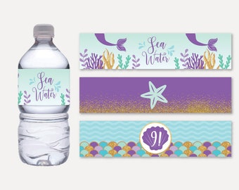 May include: Three water bottle labels with a mermaid theme. The top label is light blue with a mermaid tail and the text "Sea Water". The middle label is purple with gold glitter and a starfish. The bottom label is light blue with a purple seashell with the number "9!" inside.