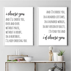 May include: Two black and white prints with romantic quotes. The first print says "i choose you and I'll choose you, over and over. Without pause, without a doubt, in a heartbeat, I'll keep choosing you." The second print says "And I'd choose you, in a hundred lifetimes, in a hundred worlds, in any version of reality, I'd find you and i'd choose you."