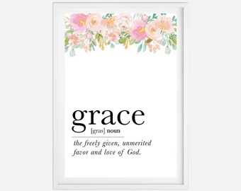 May include: A white framed print with a floral border at the top. The print features the word "grace" in black text with the definition: "[gras] noun the freely given, unmerited favor and love of God."