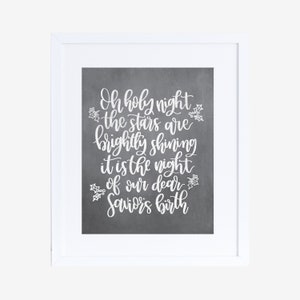 May include: A white framed print with a gray background and white text that reads "Oh holy night the stars are brightly shining it is the night of our dear Saviors birth".