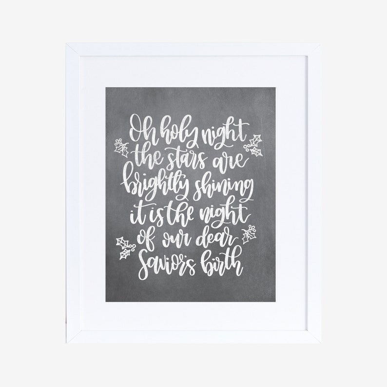May include: A white framed print with a gray background and white text that reads "Oh holy night the stars are brightly shining it is the night of our dear Saviors birth".