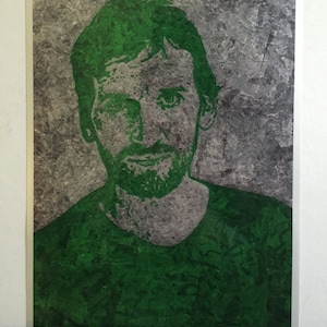 May include: A green and gray portrait of a man with a beard and short hair. The image has a textured, abstract background.